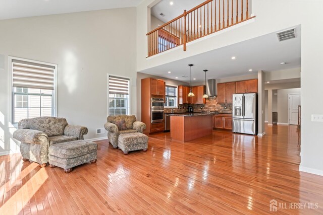 living room with light hardwood / wood-style flooring and a high ceiling