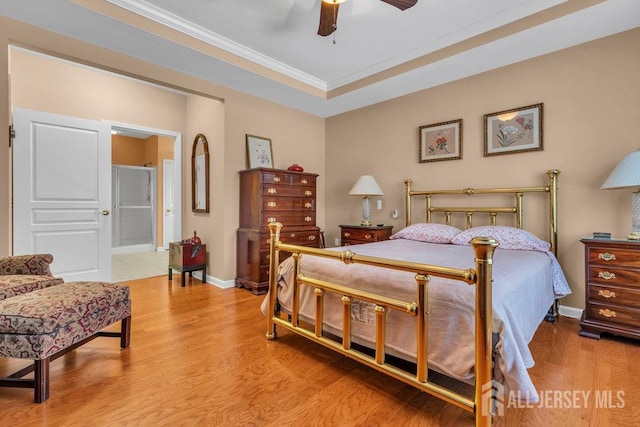 bedroom with baseboards, wood finished floors, connected bathroom, and crown molding