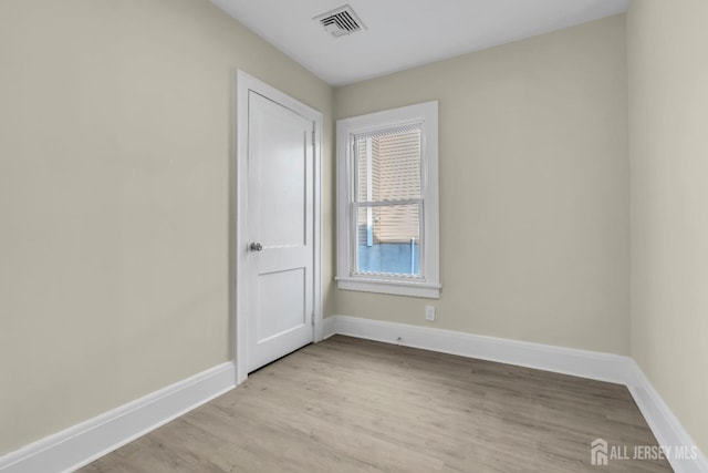 spare room with visible vents, light wood-style floors, and baseboards