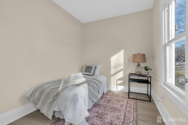 bedroom with baseboards and wood finished floors