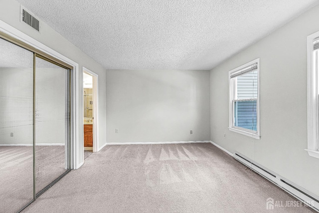 298-B Sharon Way, Monroe, NJ 08831 - unfurnished bedroom with baseboard heating, a textured ceiling, carpet floors, and a closet
