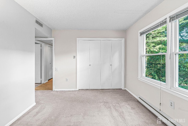 298-B Sharon Way, Monroe, NJ 08831 - unfurnished bedroom with a baseboard radiator, multiple windows, carpet, a textured ceiling, and a closet