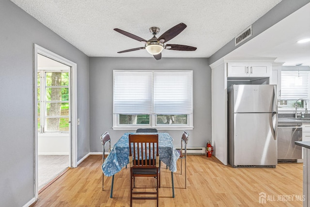 298-B Sharon Way, Monroe, NJ 08831 - dining room with baseboard heating, a ceiling fan, plenty of natural light, light wood finished floors, and a textured ceiling