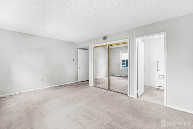 298-B Sharon Way, Monroe, NJ 08831 - unfurnished bedroom featuring baseboard heating, carpet, a textured ceiling, a baseboard radiator, and a closet
