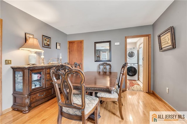 dining area featuring stacked washer / dryer and light wood-type flooring