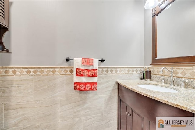 bathroom featuring vanity and tile walls