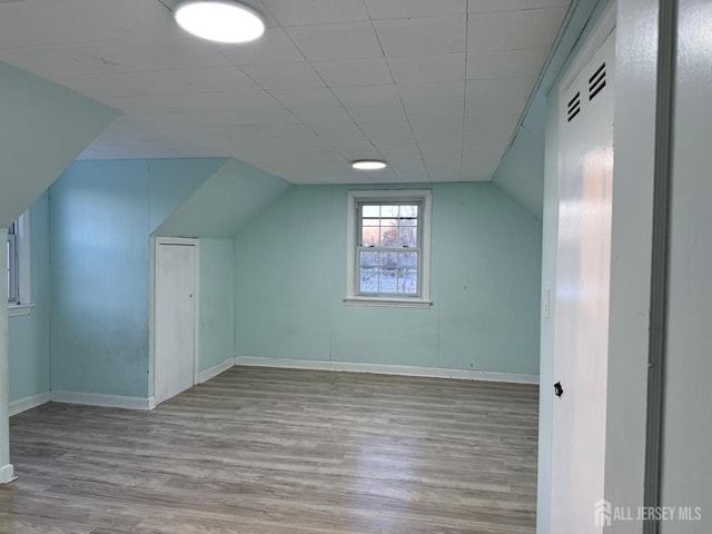 bonus room with lofted ceiling and light hardwood / wood-style flooring