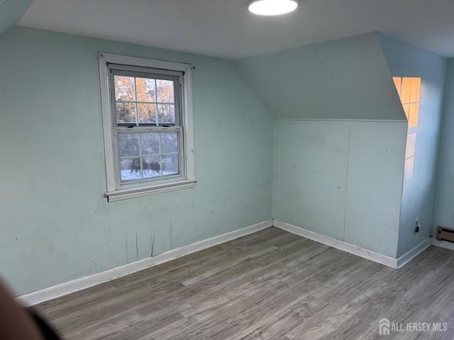 bonus room featuring hardwood / wood-style flooring, lofted ceiling, and baseboard heating