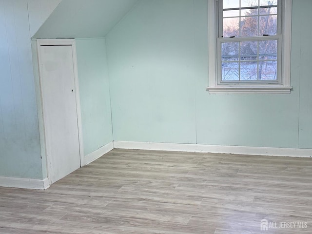 bonus room featuring lofted ceiling and light hardwood / wood-style flooring