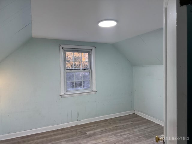 additional living space featuring lofted ceiling and hardwood / wood-style floors