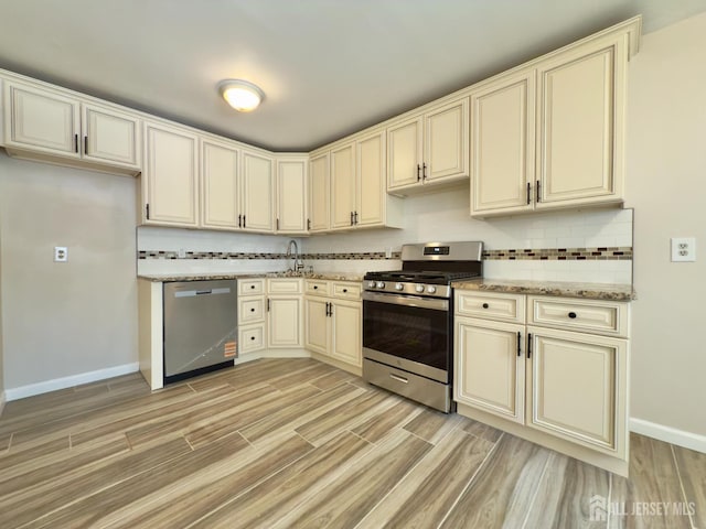 9 Lake Ave Unit 4A, East Brunswick, NJ 08816 - kitchen featuring stainless steel appliances, cream cabinets, light wood-style flooring, and decorative backsplash