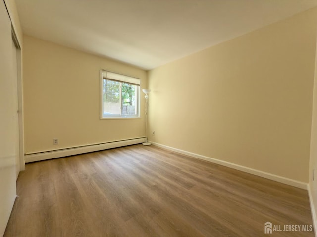 9 Lake Ave Unit 4A, East Brunswick, NJ 08816 - unfurnished bedroom featuring a baseboard heating unit and wood finished floors