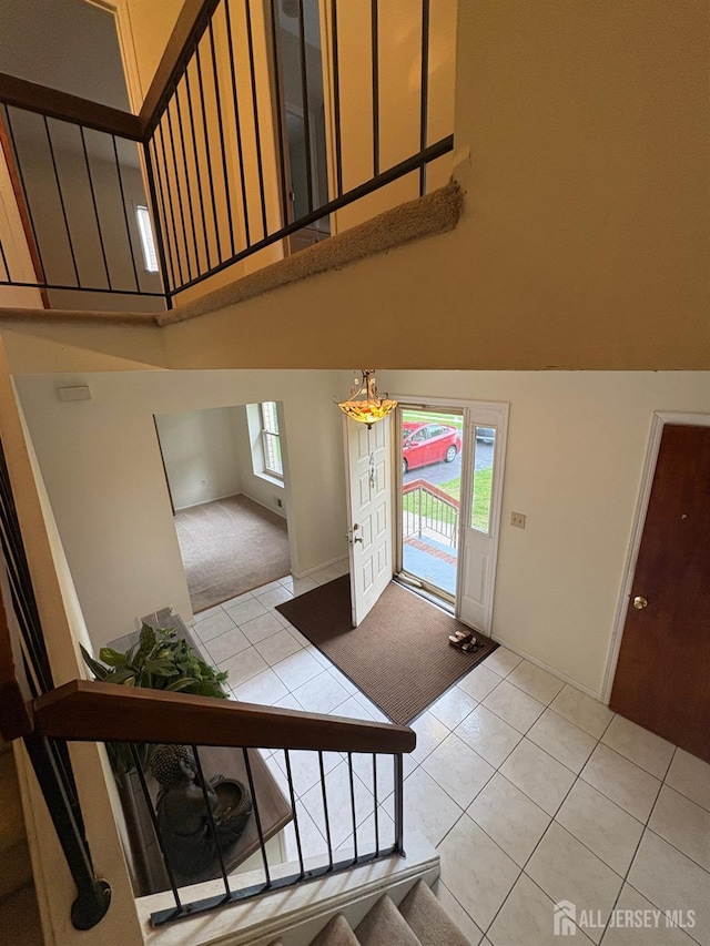 4 La Valencia Rd, Old Bridge, NJ 08857 - entryway with a high ceiling, light tile patterned floors, stairs, and light carpet