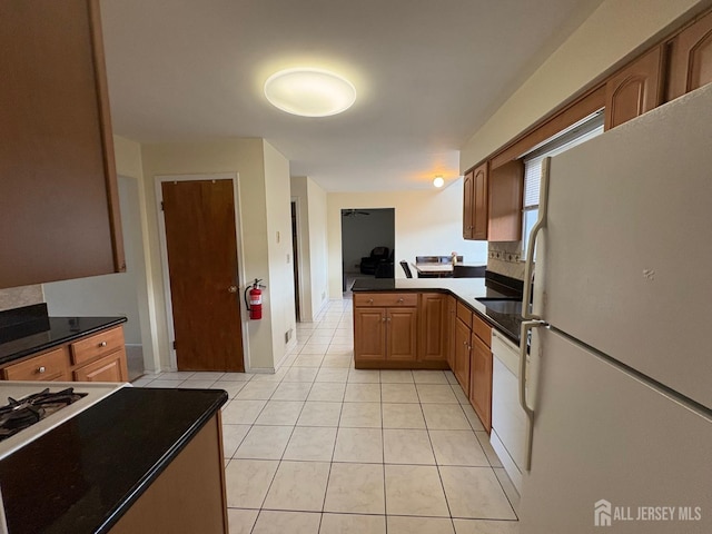 4 La Valencia Rd, Old Bridge, NJ 08857 - kitchen with white appliances, light tile patterned floors, a peninsula, and brown cabinetry