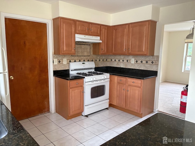 4 La Valencia Rd, Old Bridge, NJ 08857 - kitchen featuring white gas range oven, under cabinet range hood, dark stone countertops, and decorative backsplash