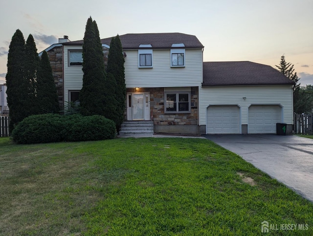 4 La Valencia Rd, Old Bridge, NJ 08857 - view of front of home featuring an attached garage, a lawn, concrete driveway, and stone siding