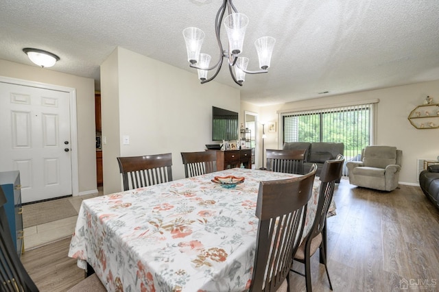 3002 Lighthouse Ln, Sayreville, NJ 08859 - dining room featuring a chandelier, a textured ceiling, and wood finished floors