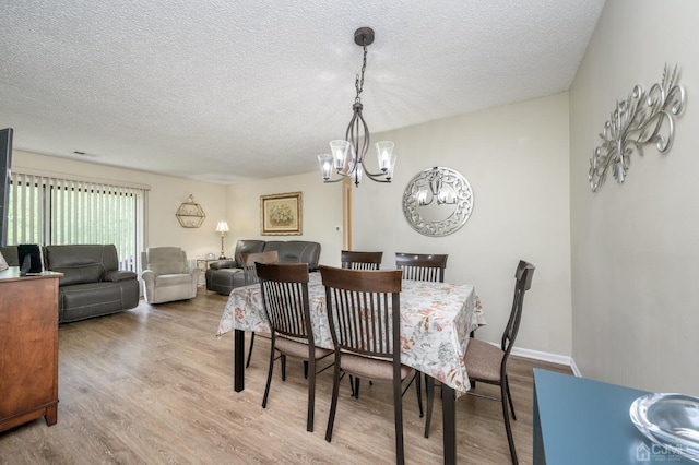 3002 Lighthouse Ln, Sayreville, NJ 08859 - dining space featuring a chandelier, a textured ceiling, and wood finished floors