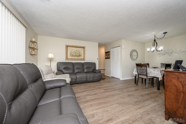 3002 Lighthouse Ln, Sayreville, NJ 08859 - living area featuring light wood-style floors, a textured ceiling, a chandelier, and baseboards