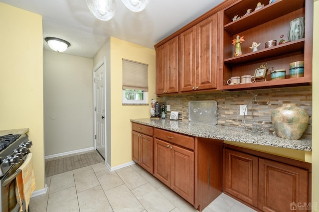 3002 Lighthouse Ln, Sayreville, NJ 08859 - kitchen with gas range, backsplash, light stone counters, brown cabinets, and baseboards