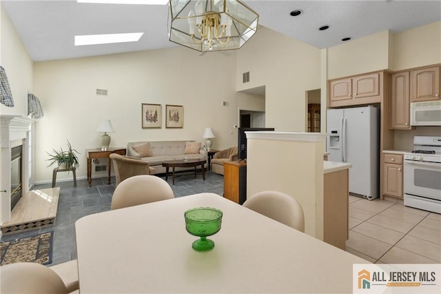 31 Cameron Ct, Monroe, NJ 08831 - dining space with a chandelier, high vaulted ceiling, a high end fireplace, a skylight, and light tile patterned flooring