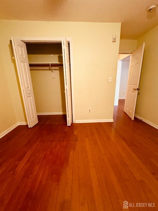 404 Newport Ct, Fords, NJ 08863 - unfurnished bedroom featuring dark wood finished floors, baseboards, and a closet