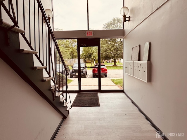 404 Newport Ct, Fords, NJ 08863 - doorway to outside featuring wood finished floors, a high ceiling, stairway, and baseboards