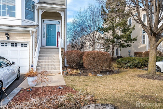 view of exterior entry featuring a lawn and an attached garage