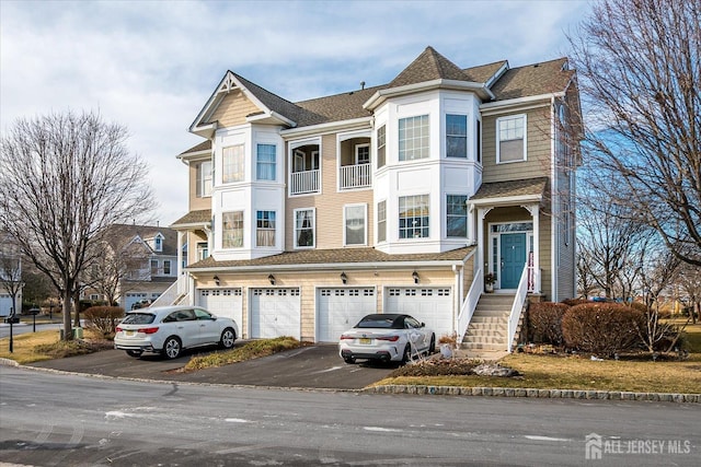 view of front of home featuring a garage, aphalt driveway, and a shingled roof