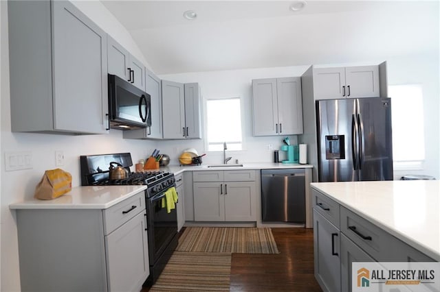 3060 Bordentown Ave, Old Bridge, NJ 08859 - kitchen featuring black appliances, gray cabinets, a sink, vaulted ceiling, and light countertops