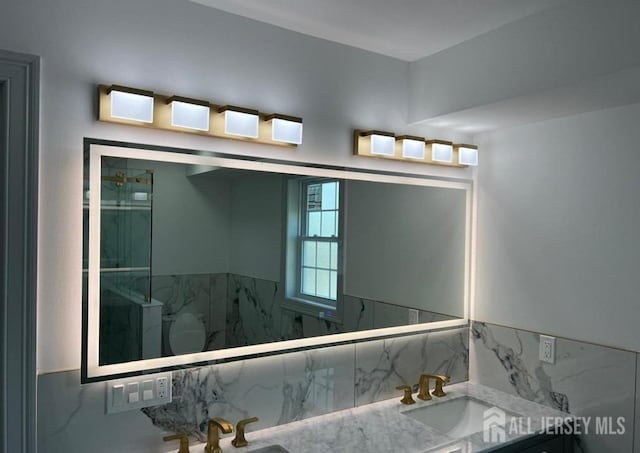 bathroom with vanity and a marble finish shower