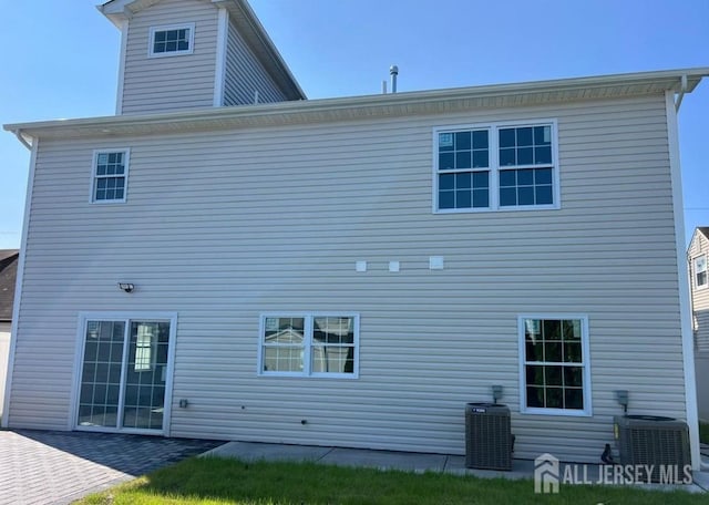 rear view of property featuring a patio area and central air condition unit