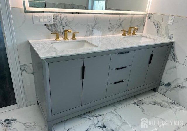 bathroom featuring a sink, marble finish floor, and double vanity