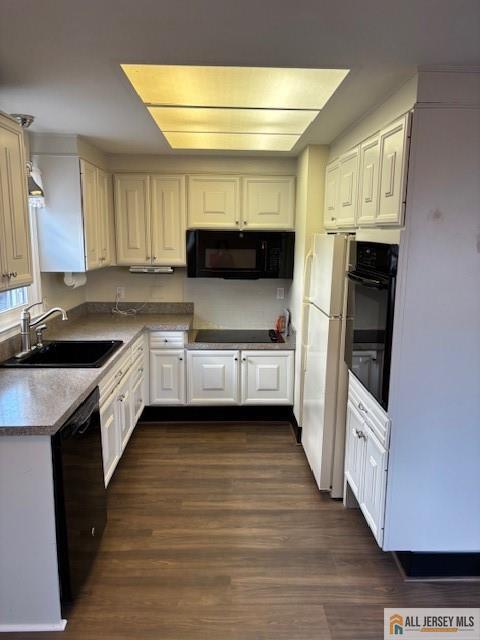 kitchen with sink, dark wood-type flooring, white cabinets, and black appliances