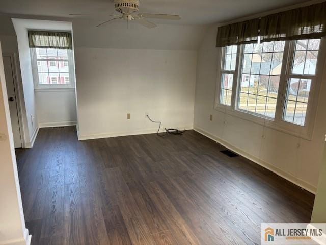 spare room featuring dark wood-type flooring, ceiling fan, and vaulted ceiling