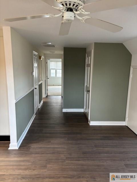 corridor with dark hardwood / wood-style flooring and lofted ceiling