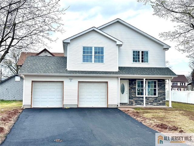 101 S Dover Ave, Franklin, NJ 08873 - view of front facade with asphalt driveway, covered porch, roof with shingles, stone siding, and a garage