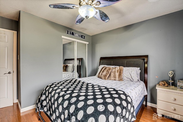 bedroom featuring a closet, wood finished floors, and baseboards