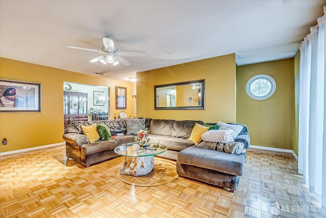 living room featuring visible vents, baseboards, and a ceiling fan