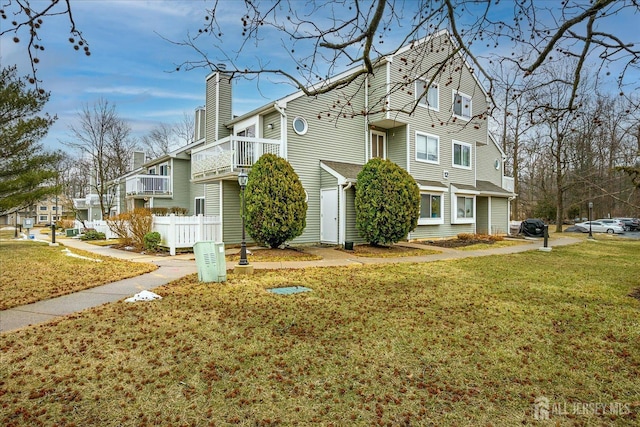 view of front of house featuring a front yard, fence, and a chimney