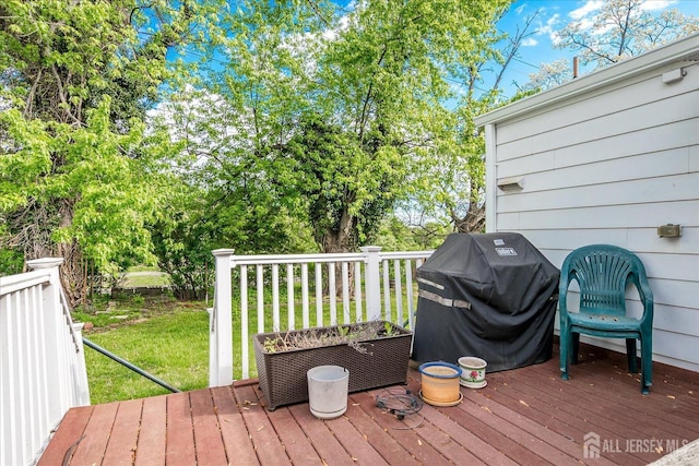 wooden deck with area for grilling and a lawn