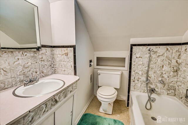 bathroom featuring toilet, vanity, baseboards, lofted ceiling, and shower / washtub combination
