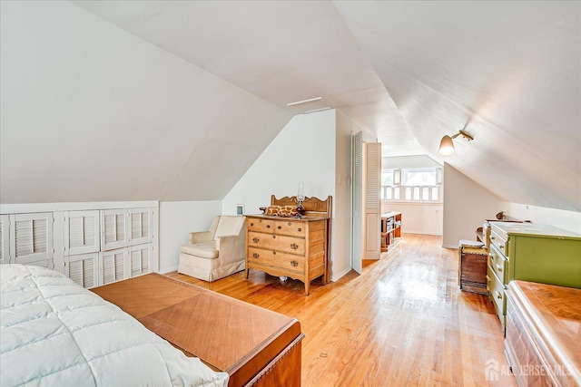 bedroom featuring light wood-style floors and vaulted ceiling