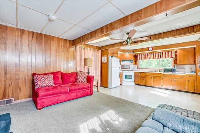 living room featuring wooden walls and a ceiling fan