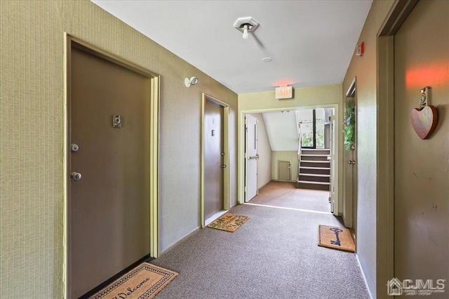 corridor with lofted ceiling and carpet