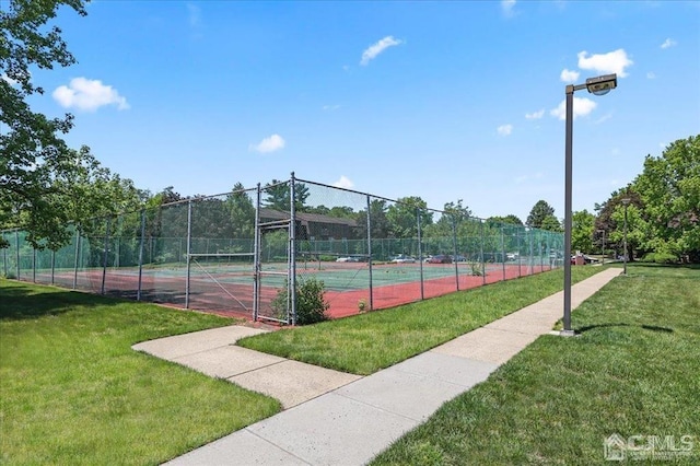 view of tennis court with a lawn