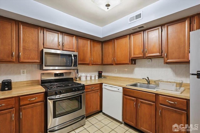 kitchen with sink, light tile patterned floors, and stainless steel appliances