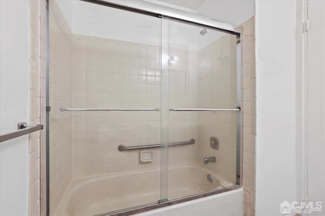 bathroom featuring combined bath / shower with glass door