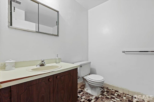 bathroom featuring vanity, toilet, and tile patterned flooring