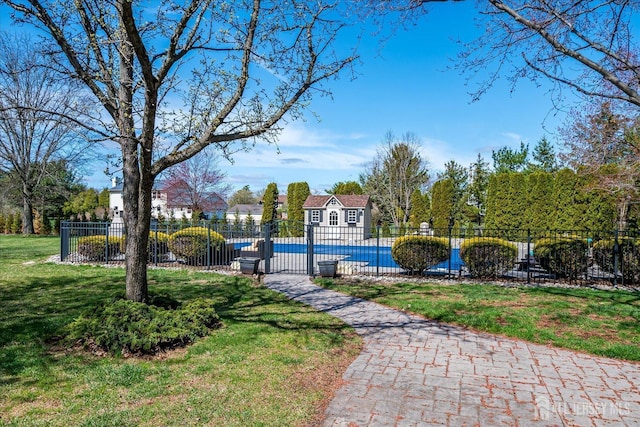 view of community with a swimming pool, a yard, an outdoor structure, and fence